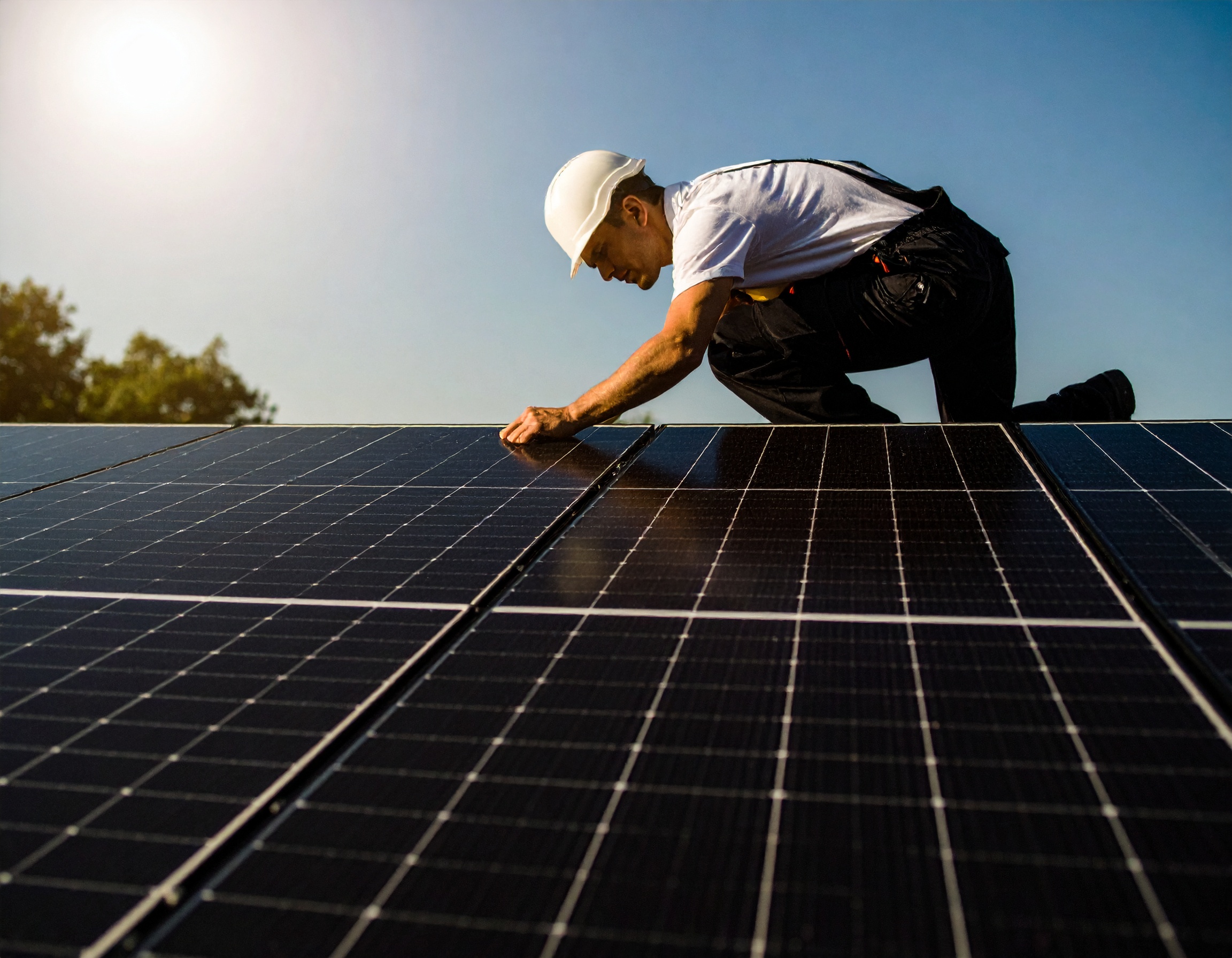 Técnico instalando placas solares sobre un tejado
